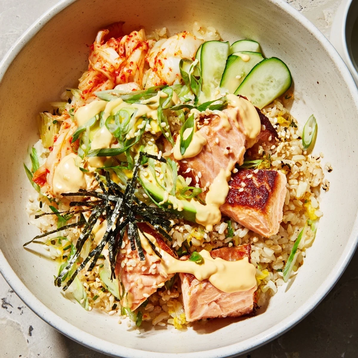 A colorful Crispy Salmon Rice Bowl topped with spicy mayo and vibrant kimchi.  