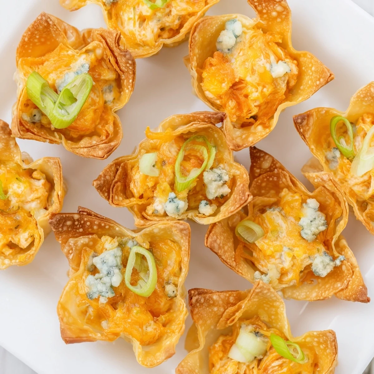 Golden-brown Buffalo Chicken Dip Pinwheel Wonton appetizers, perfect for game day with dipping sauce.