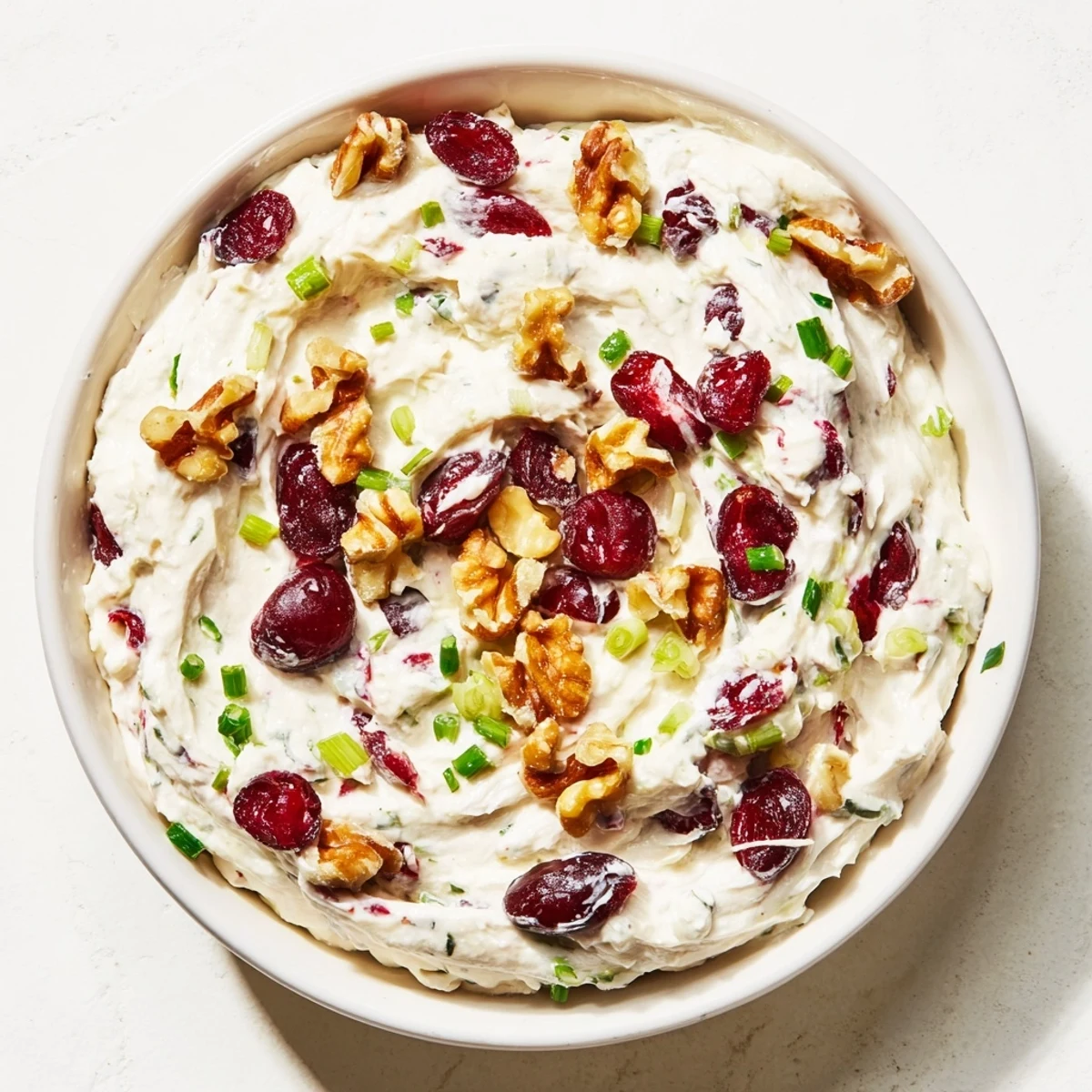 A close-up of a delightful holiday spread: lightened cream cheese dip garnished with fresh cranberries.