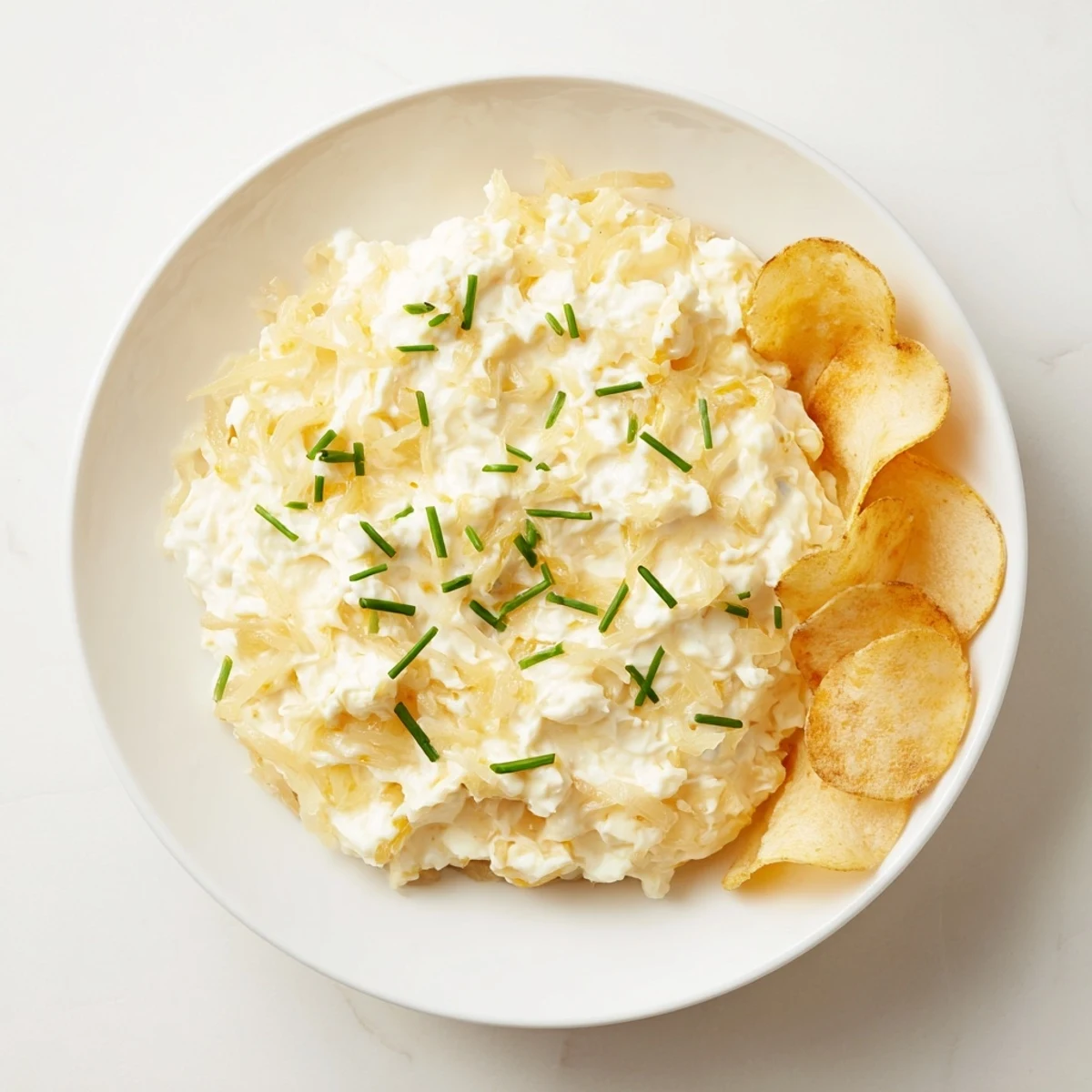 Crispy potato chips alongside a creamy onion dip, a perfect party platter for sharing.