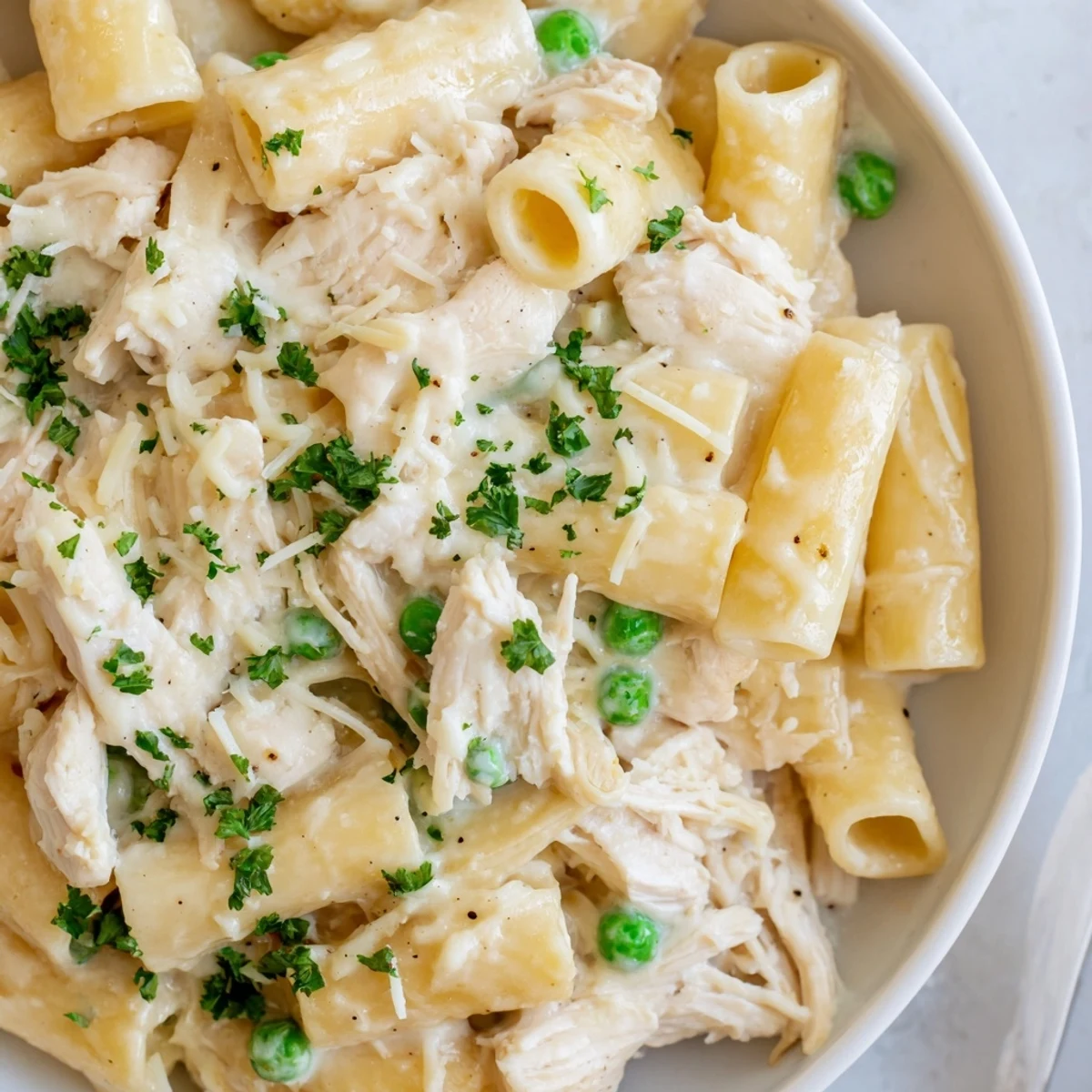Slow Cooker Chicken Alfredo Pasta Bake bubbling with cheesy goodness and tender chicken pieces.