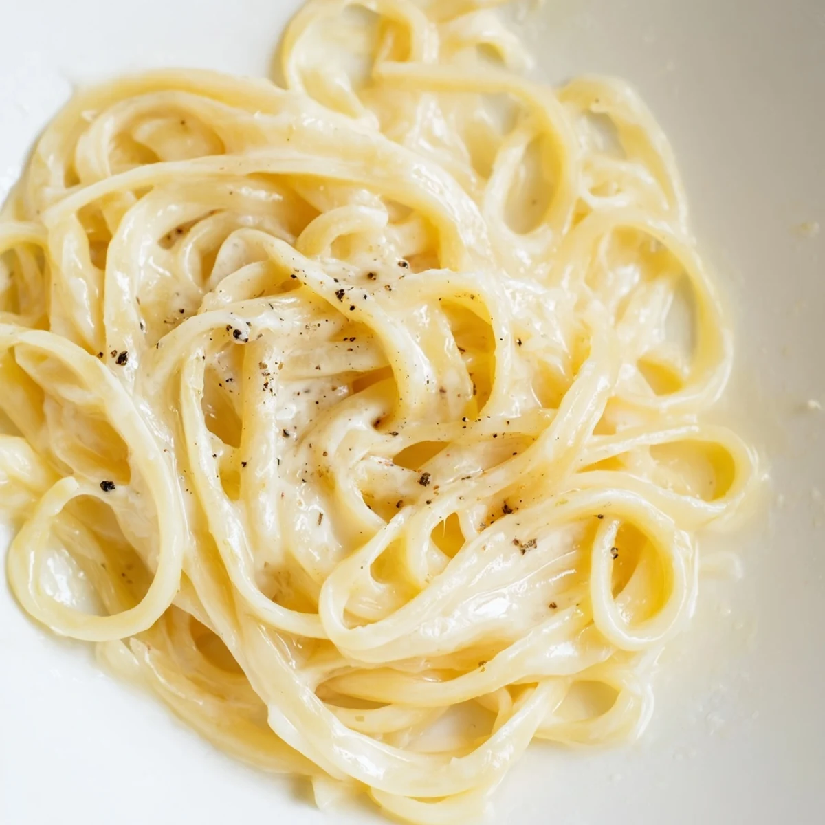 Garnished with pepper, a photo reveals the perfect texture of this simple Lazy Girl Three-Ingredient Pasta.