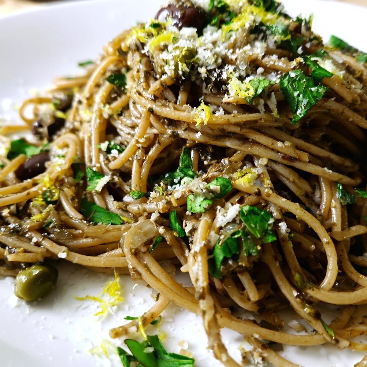 A vibrant plate of Olive Tapenade Pasta, tossed with parsley and lemon, showcasing a rich Mediterranean flavor in every forkful.