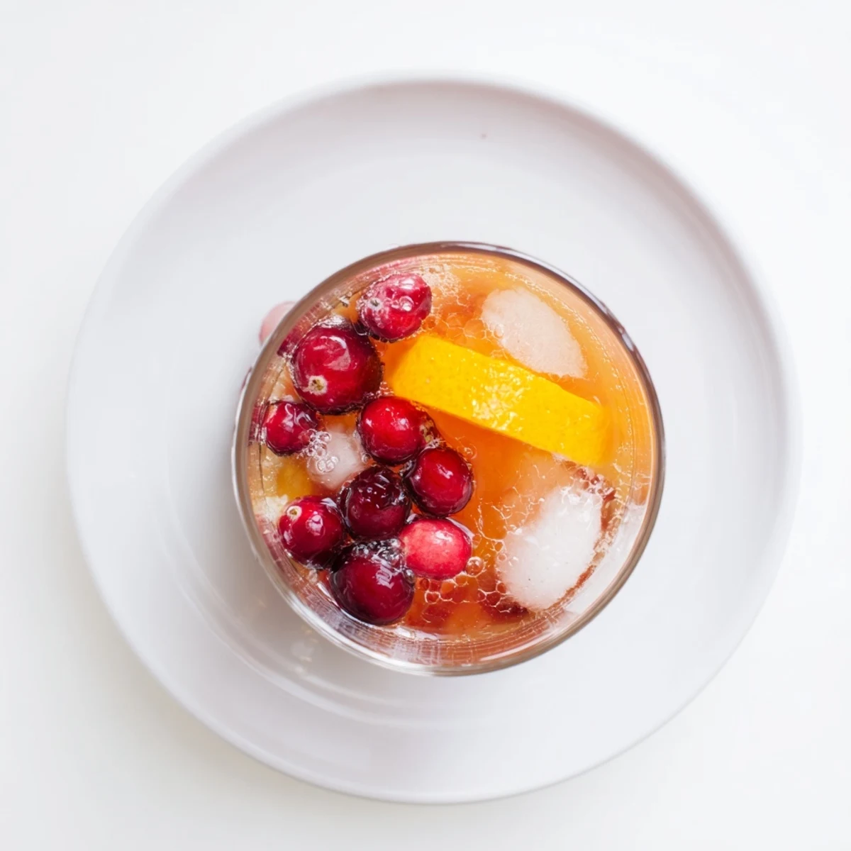 Bright red 3-Ingredient Holiday Punch, garnished with cranberries, is ready for your festive celebration.
