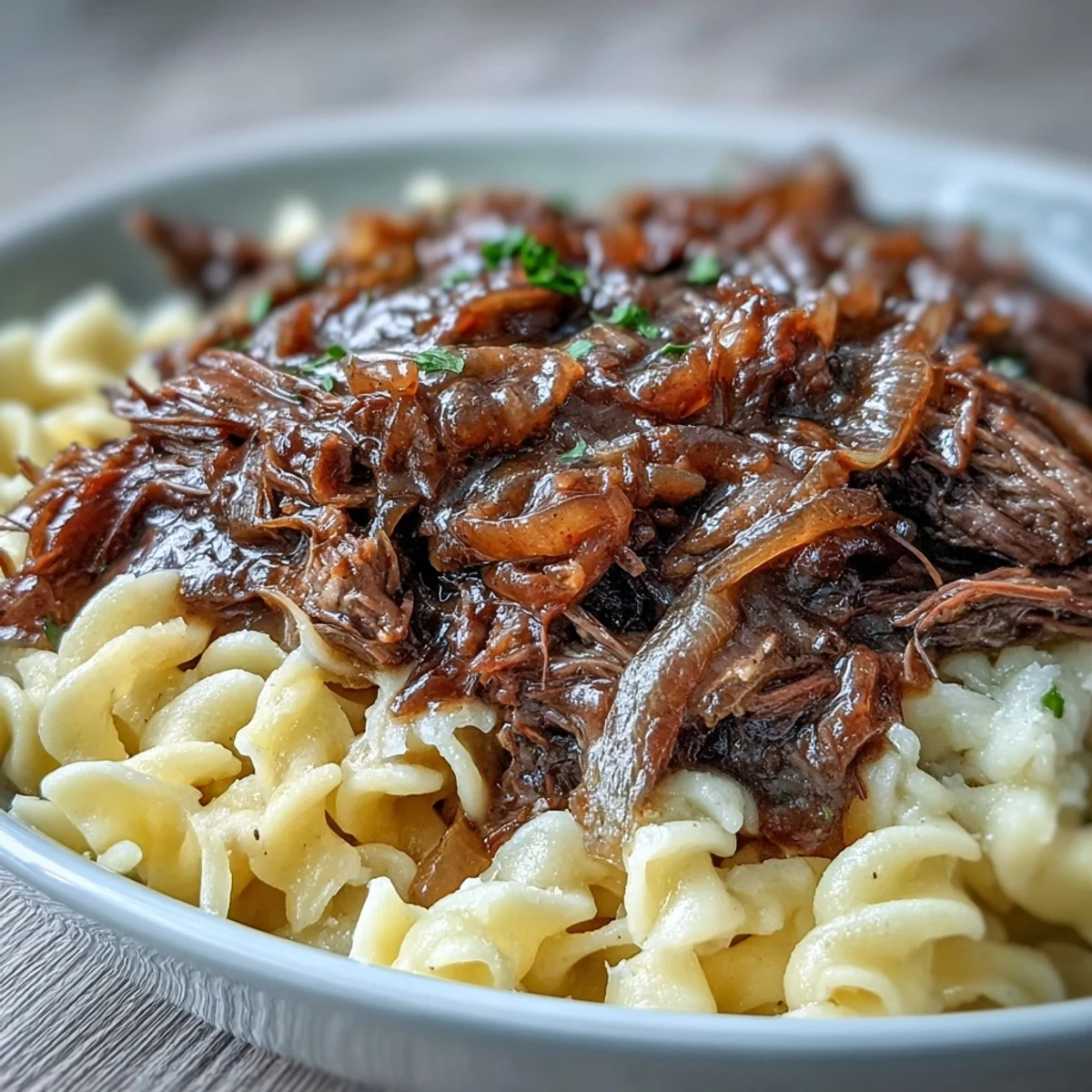 Savory Crockpot French Onion Pot Roast Pasta served family-style, with a side of crusty bread to mop up the rich gravy.