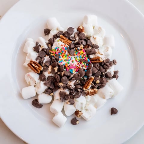 Warm and melty, this chocolate chips and mini marshmallows heap offers a sweet dessert.