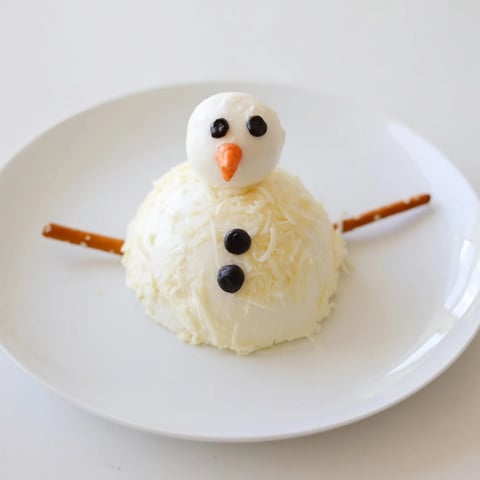 Melted Snowman Cheese Bites melting on a platter, ready to be scooped with crackers for a festive appetizer.