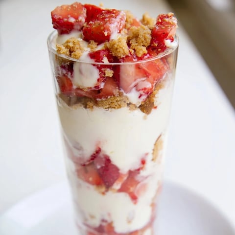 Strawberry Cheesecake Parfait layered in clear cups, showcasing creamy cheesecake and vibrant strawberries.