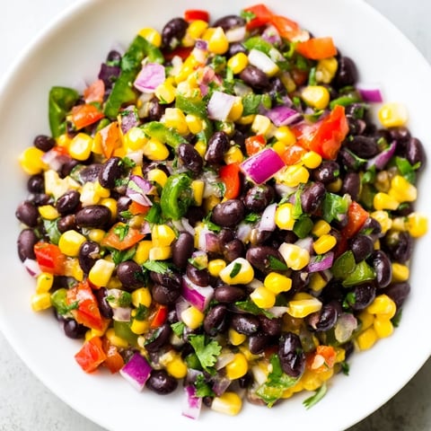 A colorful bowl of Cowboy Caviar Salad featuring black beans and sweet corn, ready to serve.