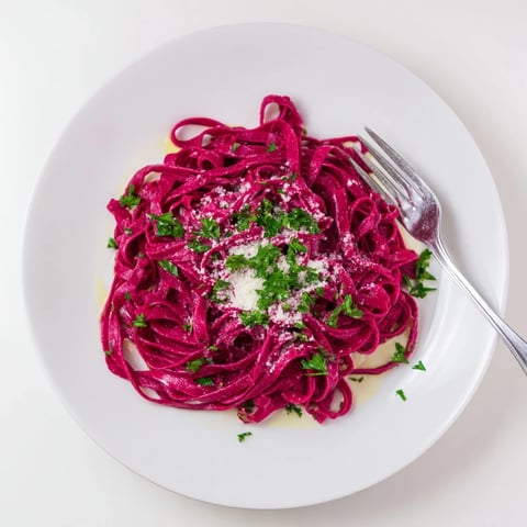 Vibrant magenta beet noodles made from roasted beet puree, tossed with fresh parsley and grated Parmesan for a colorful Italian main dish.  