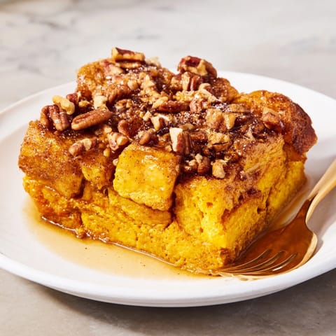 Scoops of cozy Protein Pumpkin French Toast Bake, studded with pecans, ready for serving.