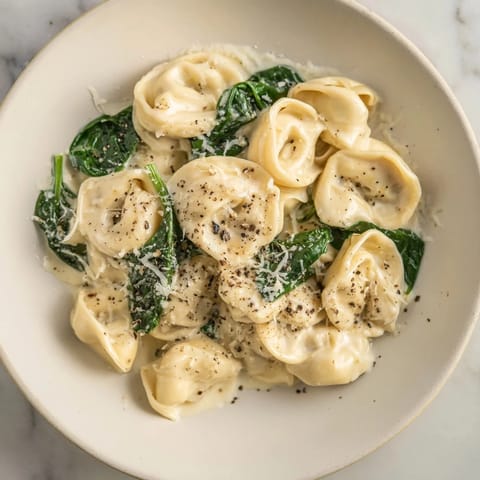 This beautiful creamy spinach Alfredo tortellini features tender cheese pasta coated in a rich sauce.