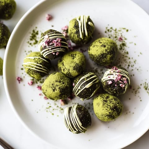 Close-up of decadent Matcha Dark Chocolate Peppermint Truffles, showcasing creamy interiors and peppermint sprinkles.
