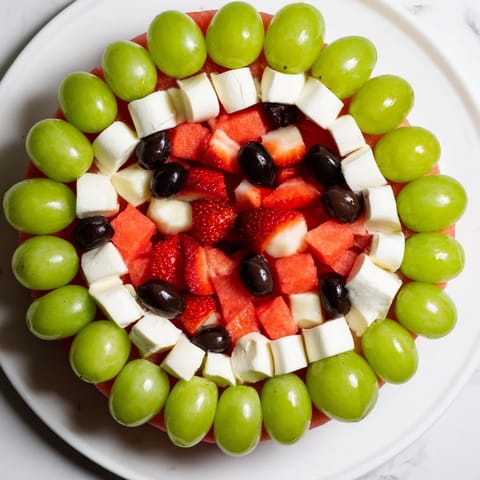 A platter of Summer Watermelon Slice: juicy watermelon with a creamy cheese layer and green olive rind.