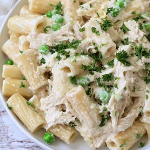Creamy Slow Cooker Chicken Alfredo Pasta Bake, perfect comfort food, topped with fresh parsley.