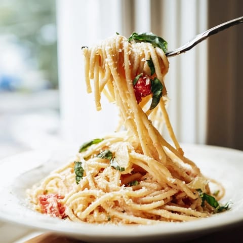 Creamy roasted garlic pasta sauce tossed with linguine, topped with grated Parmesan and a pinch of red pepper flakes.