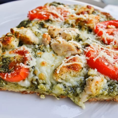 This homemade Chicken Pesto Pizza features fragrant basil pesto and tender chicken on a crisp crust.