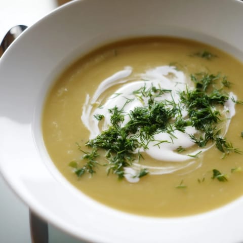 Savory Parsnip and Herb Soup ladled into a bowl, topped with fresh parsley and chives.  