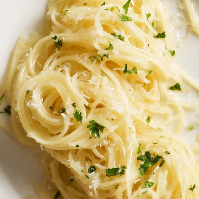 A close-up of Lemon Butter Pasta Light in a white bowl, showcasing its glossy texture and vibrant citrus zest.  