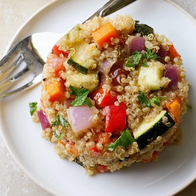 Fluffy Quinoa Vegetable Pilaf served warm as a hearty main dish, featuring golden roasted vegetables and a sprinkle of fresh parsley.  