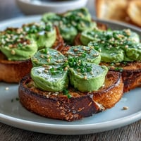 Shamrock Avocado Toast with Everything Seasoning topped with vibrant avocado shamrocks and savory seasoning blend.  