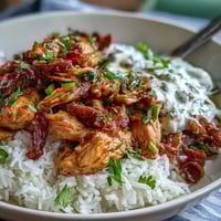 Hearty Crockpot Mississippi Chicken Rice Bowls with tender shredded chicken and zesty pepperoncini over fluffy white rice.
