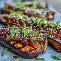 Miso glazed eggplant halves roasted until tender and caramelized with a savory-sweet umami topping.